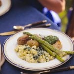 A plate of pasta and asparagus with wedding details.