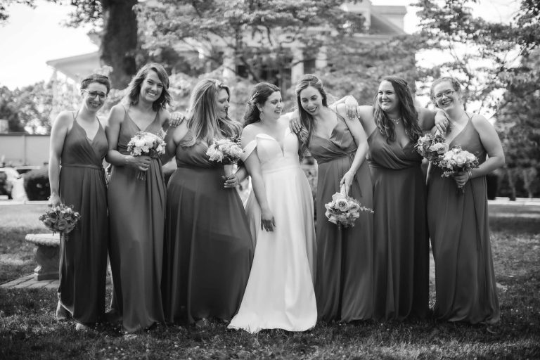 A black and white wedding portrait of bridesmaids posing for a photo.