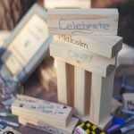 A table with wooden blocks and markers on it, showcasing wedding details.