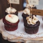 Red velvet cupcakes on a wedding cake stand with intricate details.