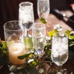 A wedding table setting with candles, eucalyptus leaves, and intricate details.
OR
A wedding table setting with elegant candle arrangements and eucalyptus leaves.