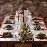 A beautifully decorated wooden table set with plates and napkins, showcasing intricate wedding details.