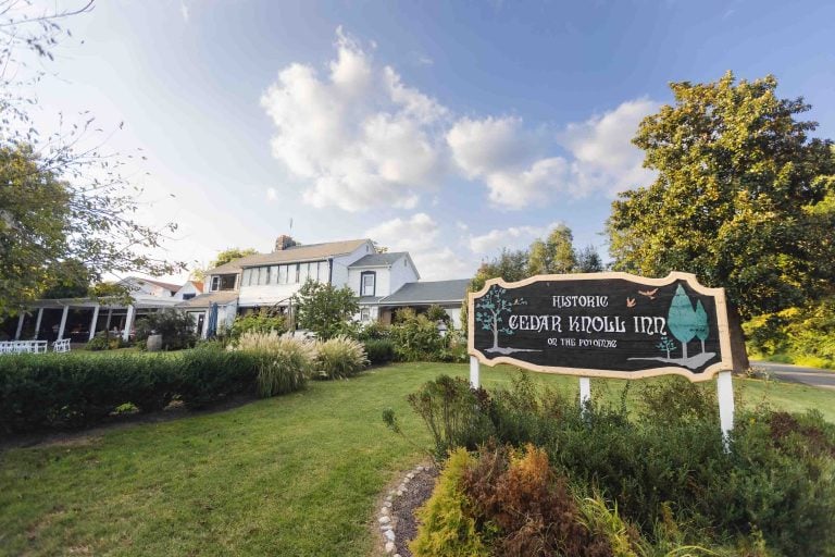 A sign in front of a wedding house in front of a grassy area.