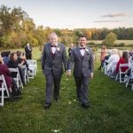 Two grooms having a wedding ceremony.