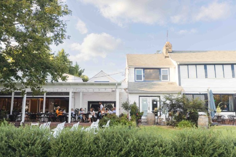 A white house with people sitting outside of it, ideal for wedding portraits.