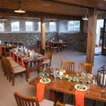 A detailed wedding setup with tables and chairs in a room.