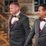 Groomsmen in tuxedos descending the stairs at a wedding reception.