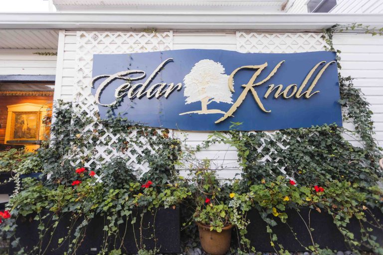 Cedar knoll is a wedding venue with a sign that says cedar knoll.