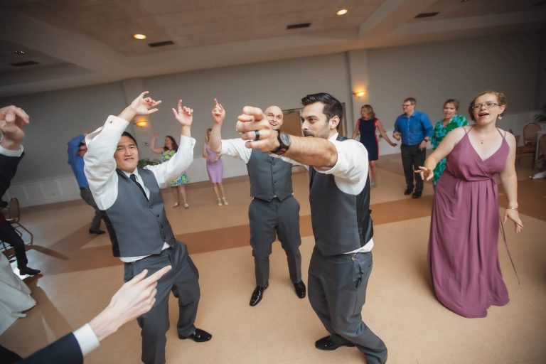 A group of people dancing at a wedding reception.