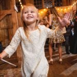 Little girl dancing on the dance floor at a wedding reception.