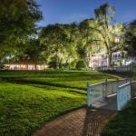 A pathway leading to a house in a grassy area at night, adorned with intricate details.