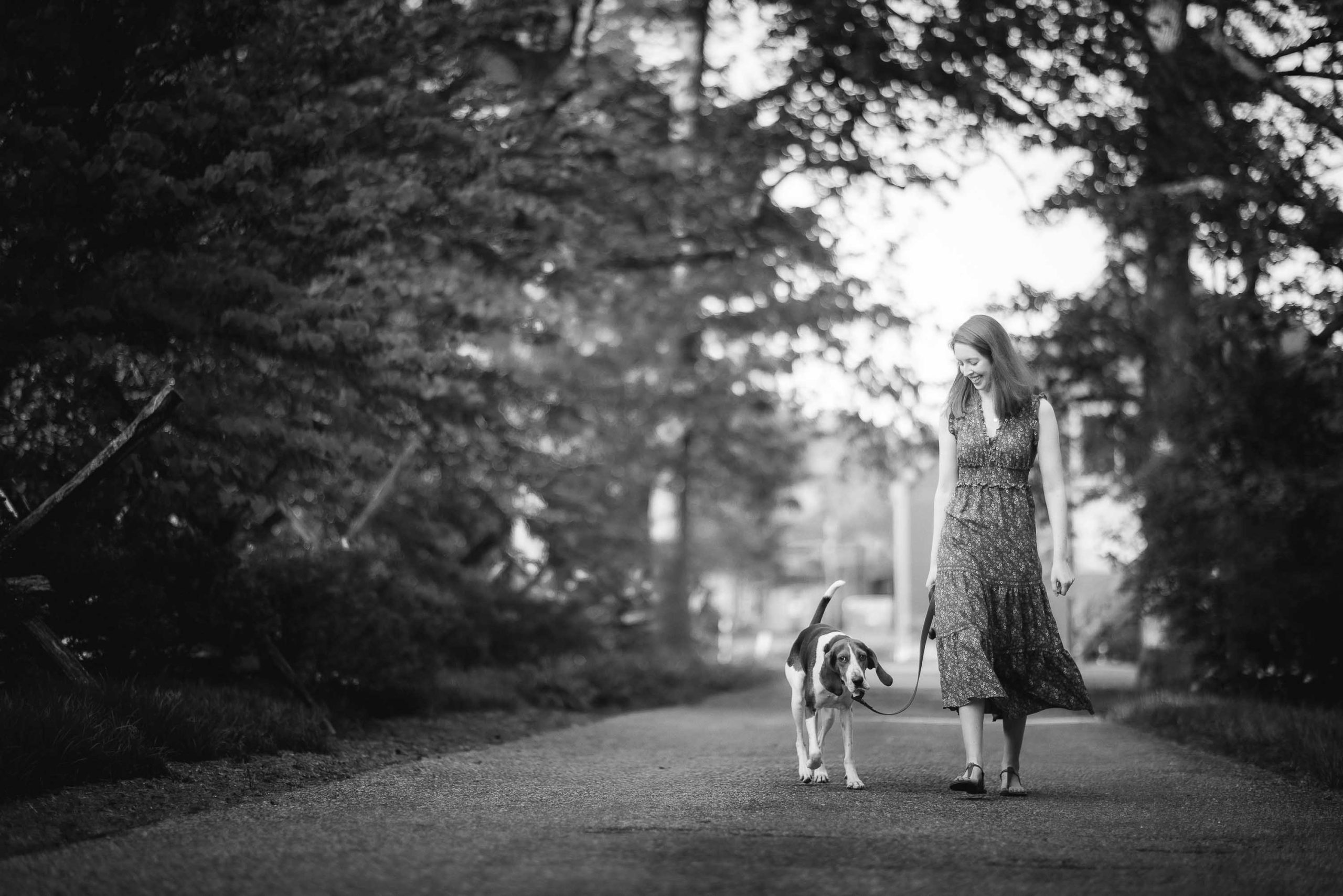 Black and white photo of a woman walking her dog at Montpelier Mansion.