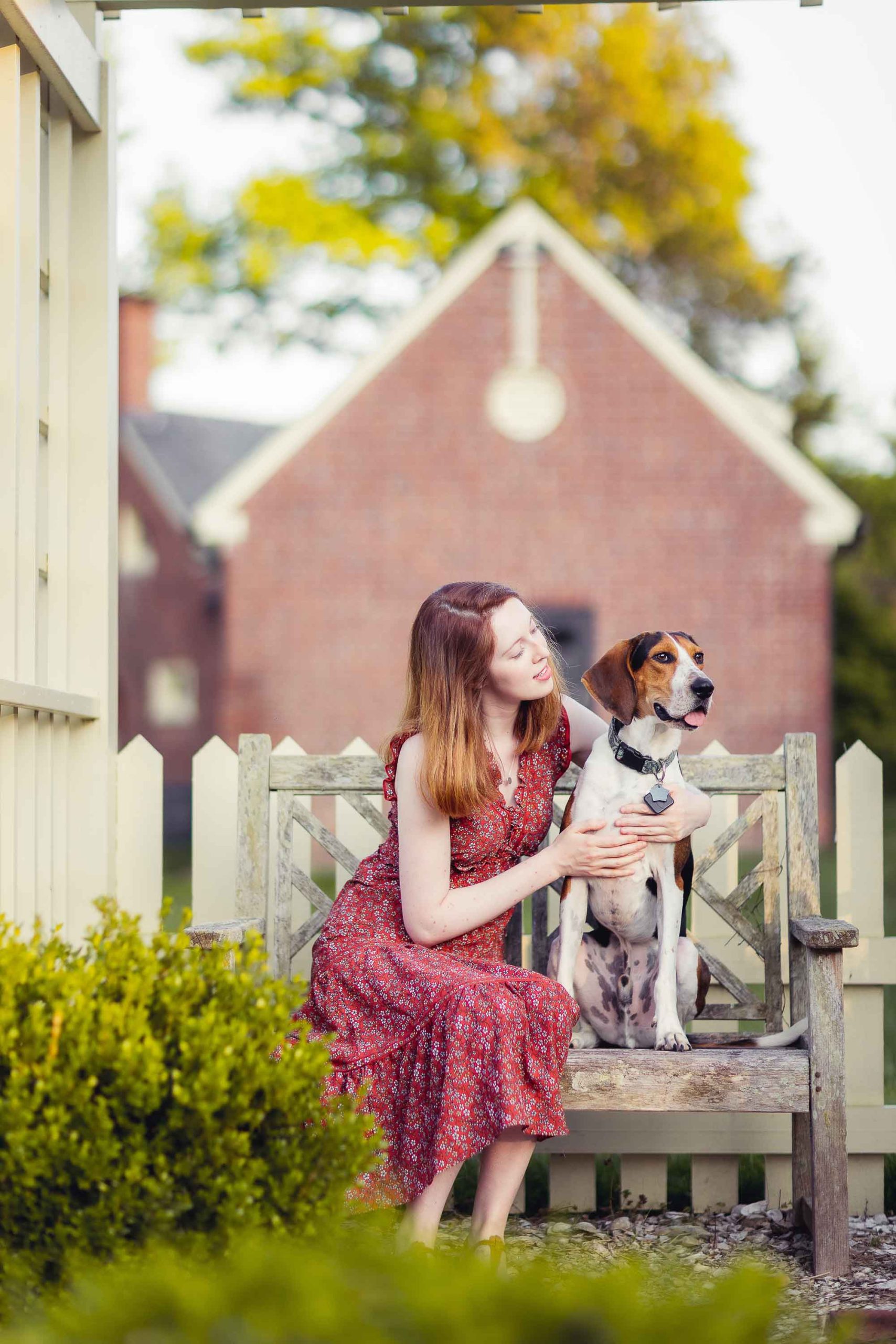 A woman shares a dog portrait on a bench.