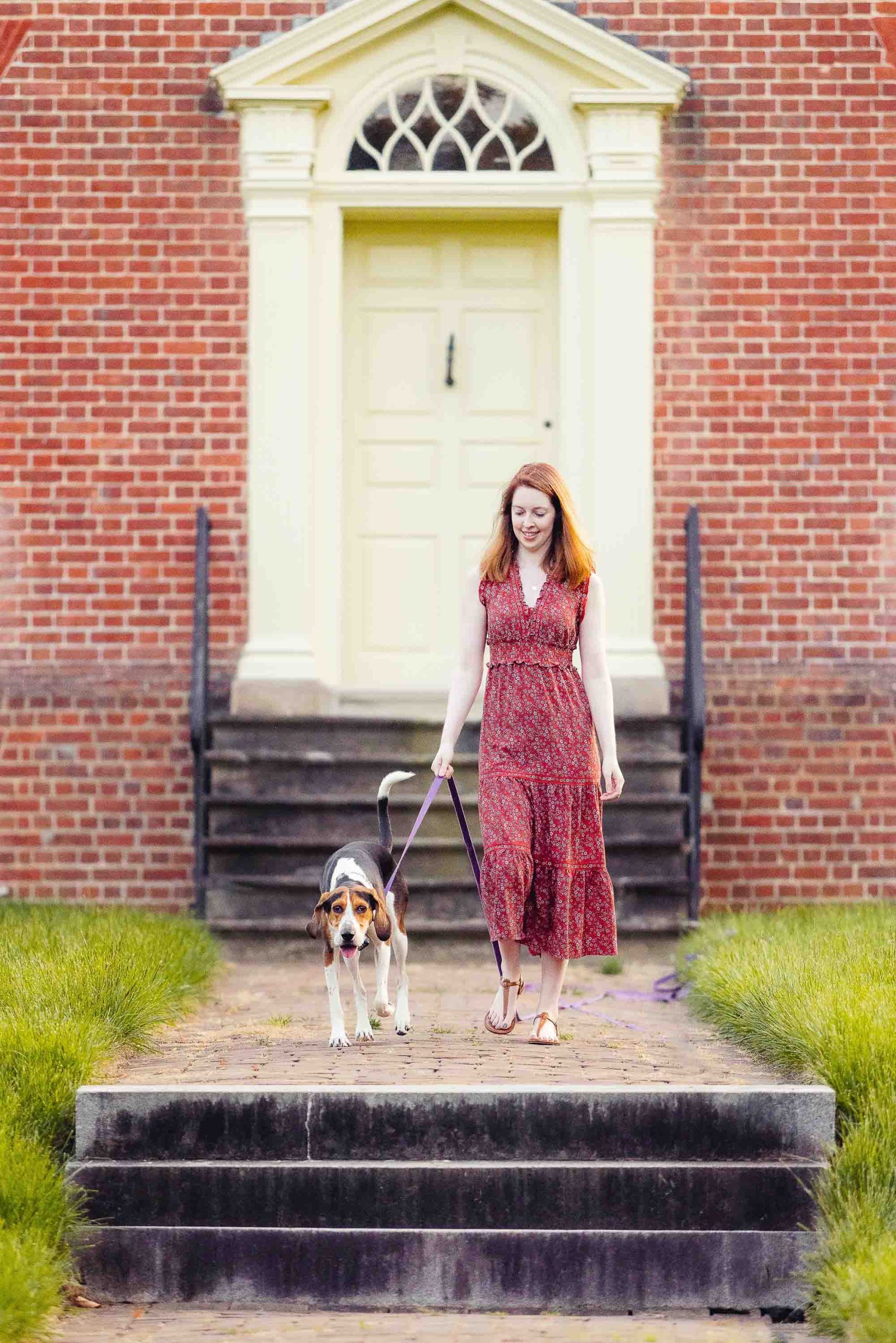 A woman walking her dog down the steps of Montpelier Mansion.