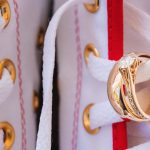 A wedding ring is intricately tied to a pair of shoes, highlighting the attention to detail.