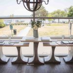 A birthday party table set up in front of a window overlooking a lake.