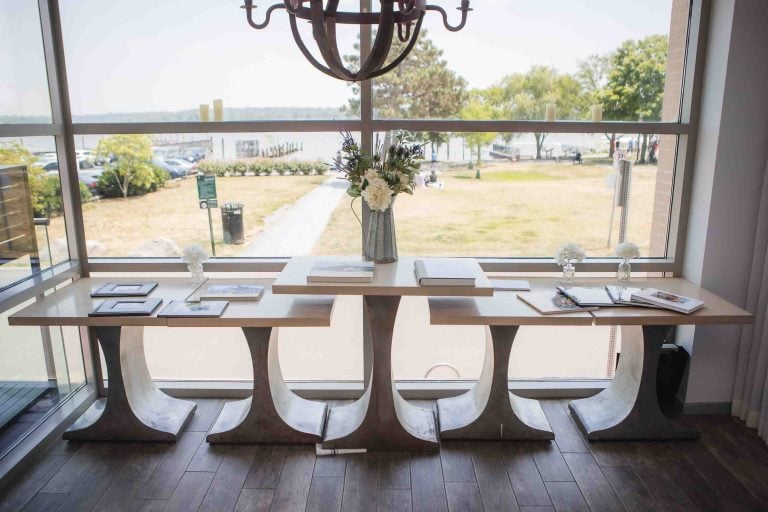 A birthday party table set up in front of a window overlooking a lake.