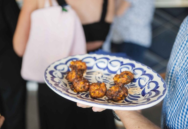 A person holding a plate of food at a birthday party.