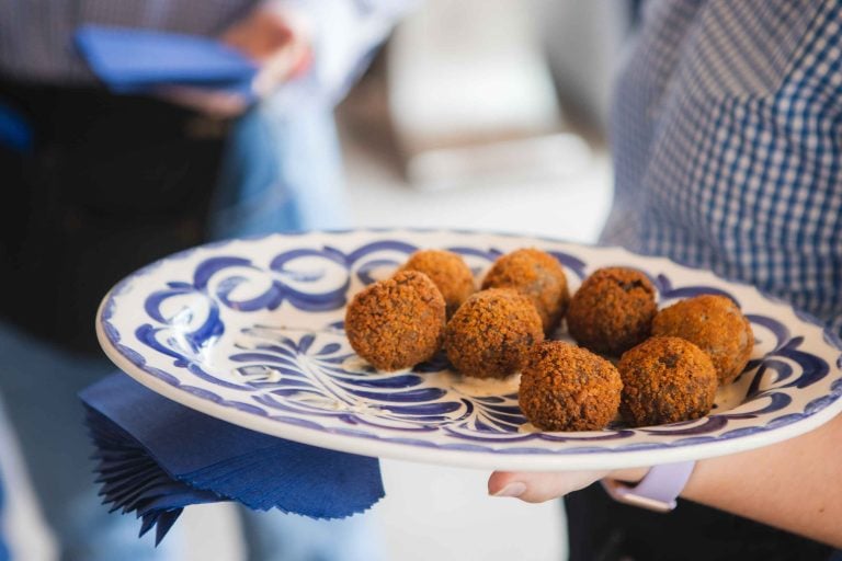 A person is holding a plate at a birthday party.