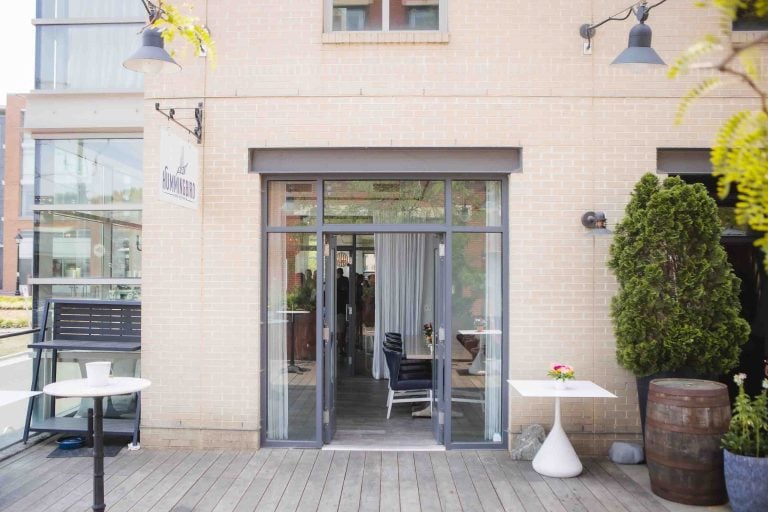 The entrance to Hummingbird Bar & Kitchen in Alexandria, Virginia with a table and chairs.