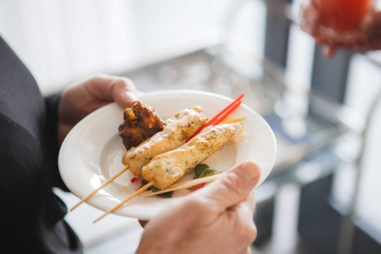 A person holding a plate of food at a birthday party.