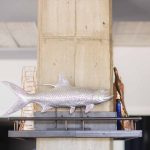 A fish sculpture is displayed on a shelf at a birthday party.