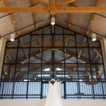 A wedding dress hangs elegantly from the ceiling, adorned with intricate details.