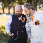 Two men in wedding attire standing next to each other.