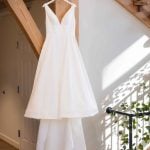 A wedding dress hangs in a room.