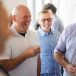 A group of men laughing at a birthday party.