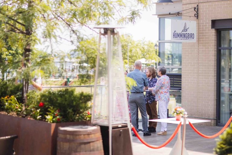 A group of people standing in front of Hummingbird Bar & Kitchen in Alexandria, Virginia.