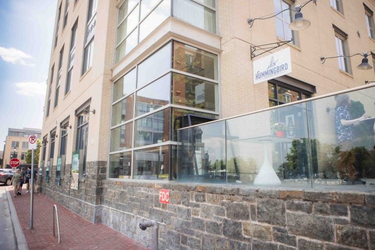 A glass facade building in Alexandria with a sidewalk.