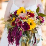 A wedding bride holding a bouquet of sunflowers.