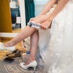 A bride is preparing for her wedding, putting on her shoes.