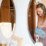 A woman candidly pouring water into a glass in preparation for a wedding.