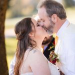 A couple kisses during their wedding ceremony.