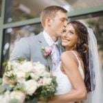 A candid bride and groom kissing during wedding preparation.