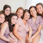 A group of bridesmaids preparing for a candid wedding photo.