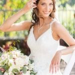 A bridal portrait of a bride in a white dress sitting on a chair.