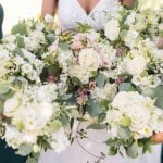 Details of a wedding ceremony with a bride and her bridesmaids holding bouquets.