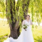 A wedding portrait of a bride under a willow tree.