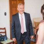 A candid groom in a suit preparing for his wedding.