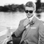 A black and white photo of a man in a suit, sunglasses, and portrait.