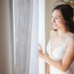 A candid bride in wedding dress during preparation.