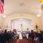 A wedding ceremony with a bride and groom walking down the aisle in a church.