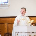 A priest giving a speech at a wedding ceremony.