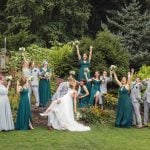 A group of bridesmaids and groomsmen pose for a wedding portrait.