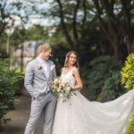 A wedding portrait captured of a bride and groom in a park.