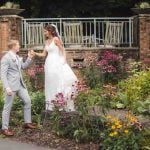 A wedding portrait in front of a flower garden.