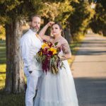 A couple posing in front of a tree during their wedding.